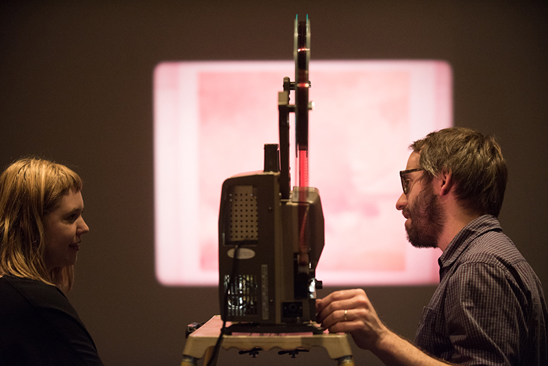 two people beside a film projector