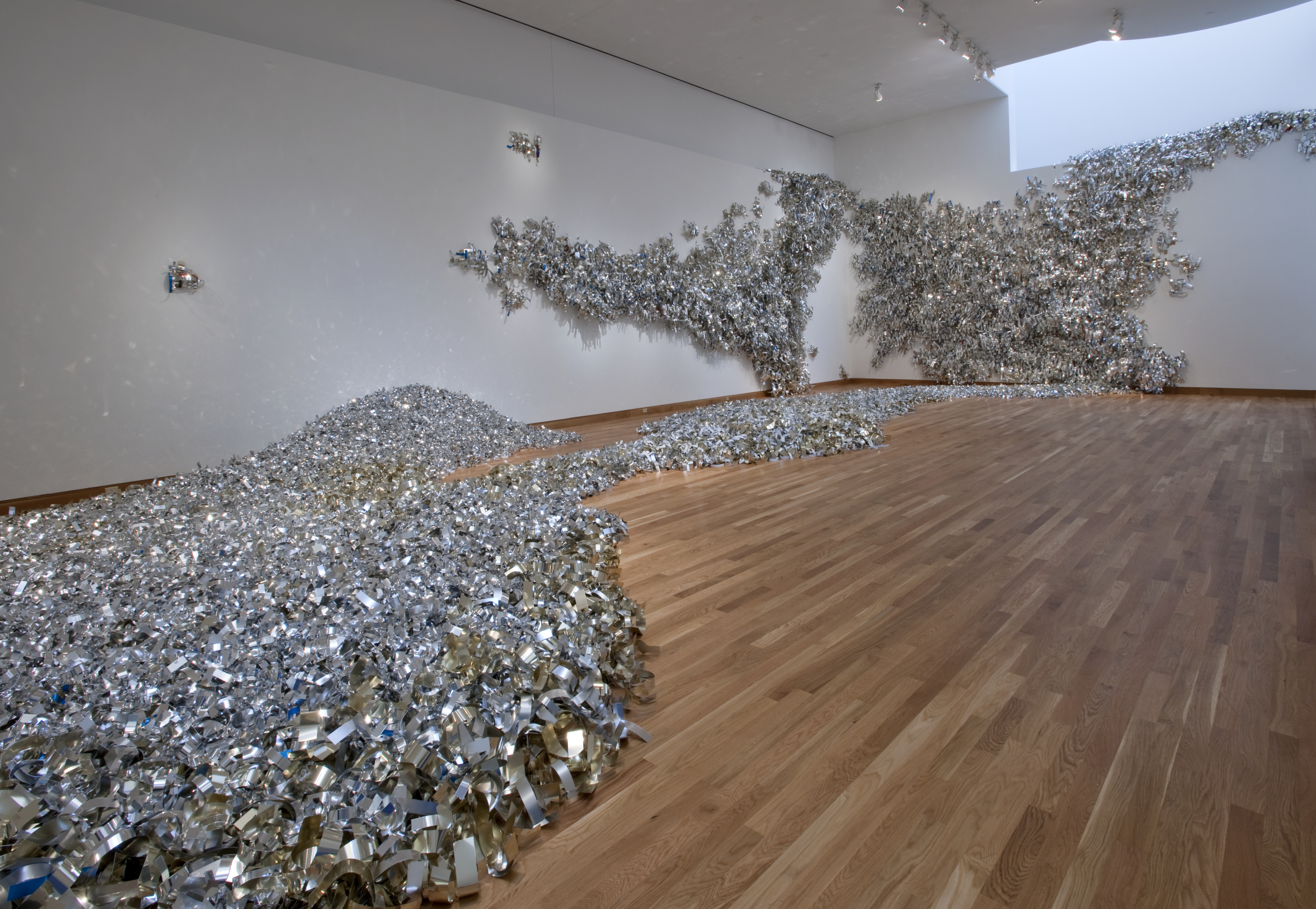 heaps of shiny material on the gallery floor and walls