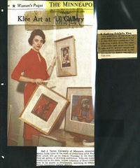 newspaper clipping of a person hanging paintings