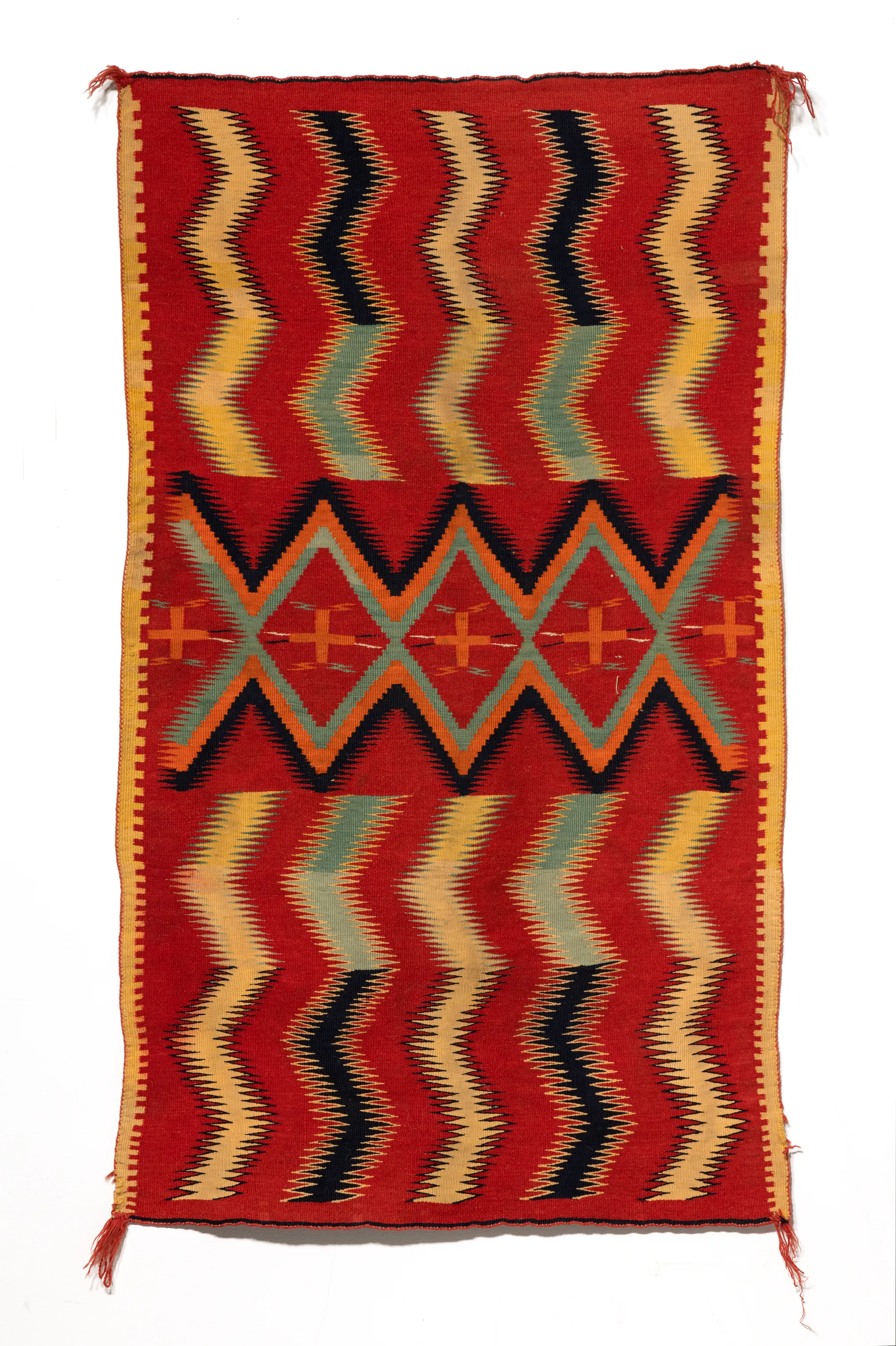 Artist unknown, this Navajo rug from the1890s contains bright reds, yellows, and oranges in geometric vertical patterns.