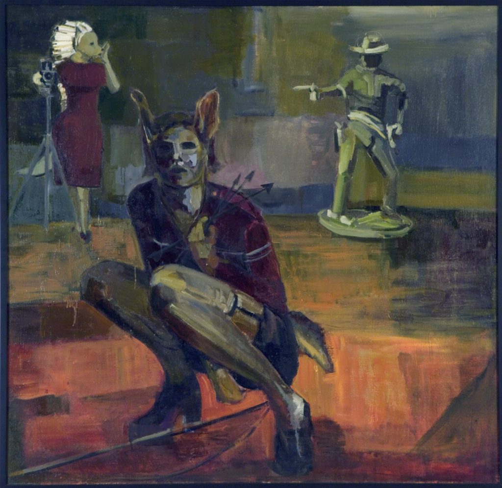 At the foreground is a half-human, half-coyote figure crouching and holding arrows, a bow at their feet. Behind this figure is a second coyote figure adorned in a red dress operating a camera while a life-size, plastic cowboy figurine aims a gun. The bottom of the image is washed in reds and browns, and the background is washed in greens and blues.
