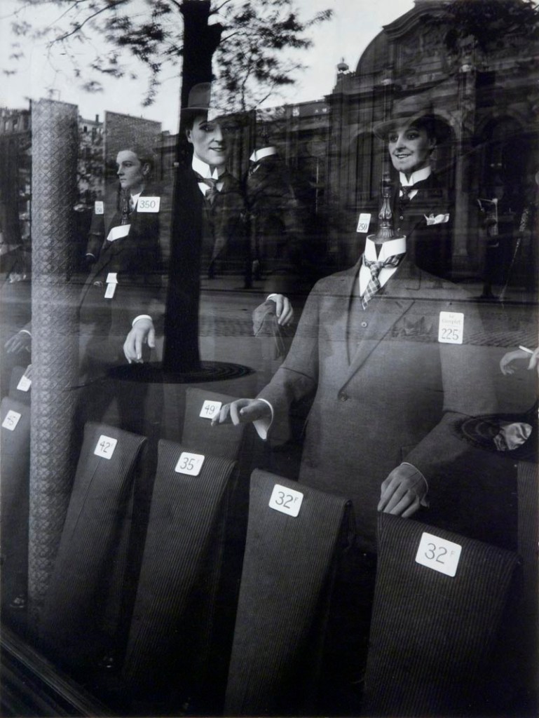 mannequins sporting mens suits behind shop window