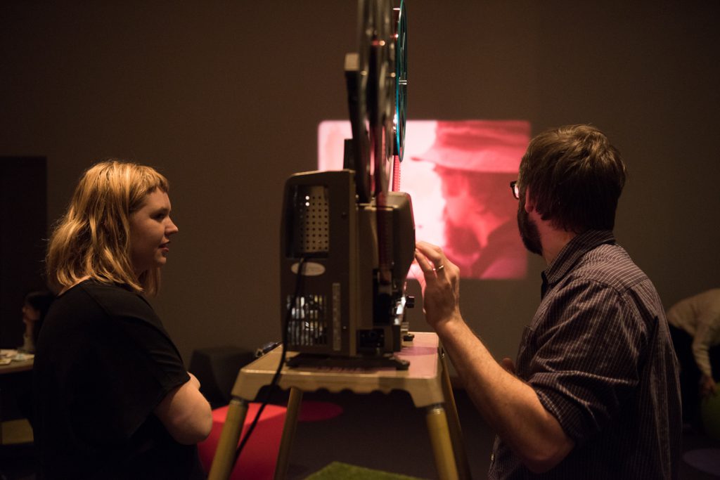 Two people operating a movie projector