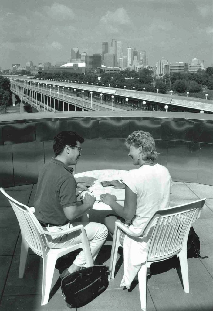 2 people sitting at a table on a balcony
