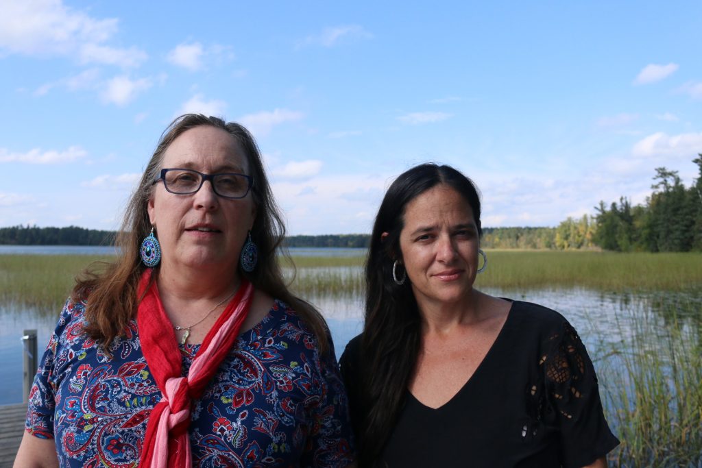 Karen Goulet and Monique Verdin in front of a lake