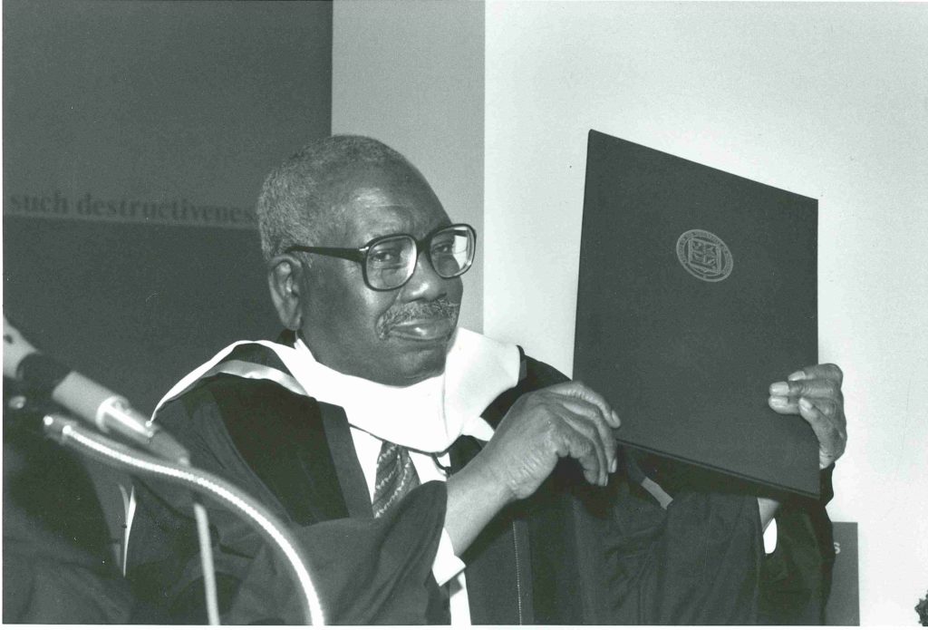 Lawrence holding up a degree