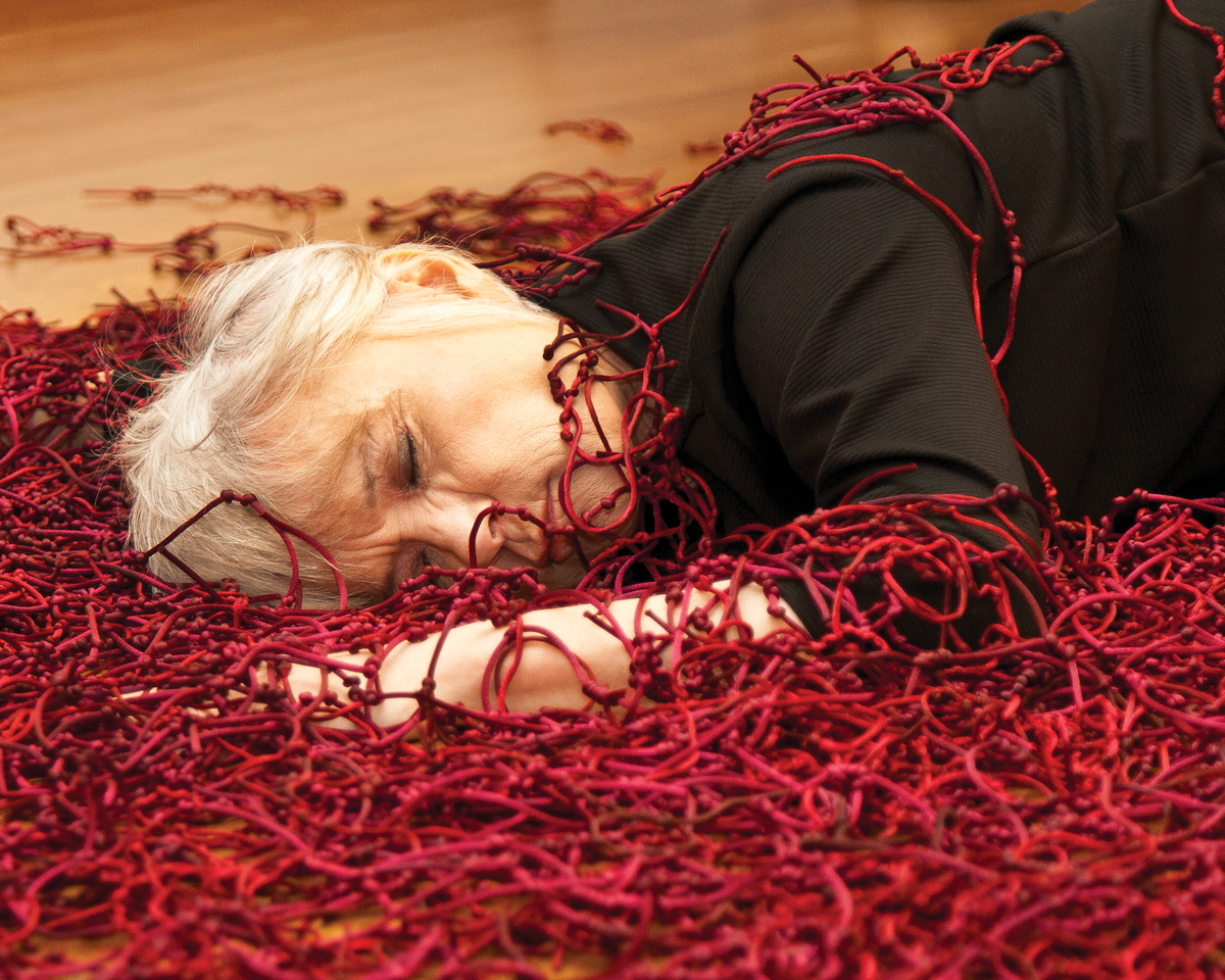 A person in a pile of red threads