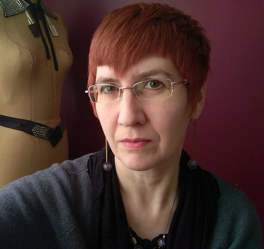 Woman with short auburn hair and glasses