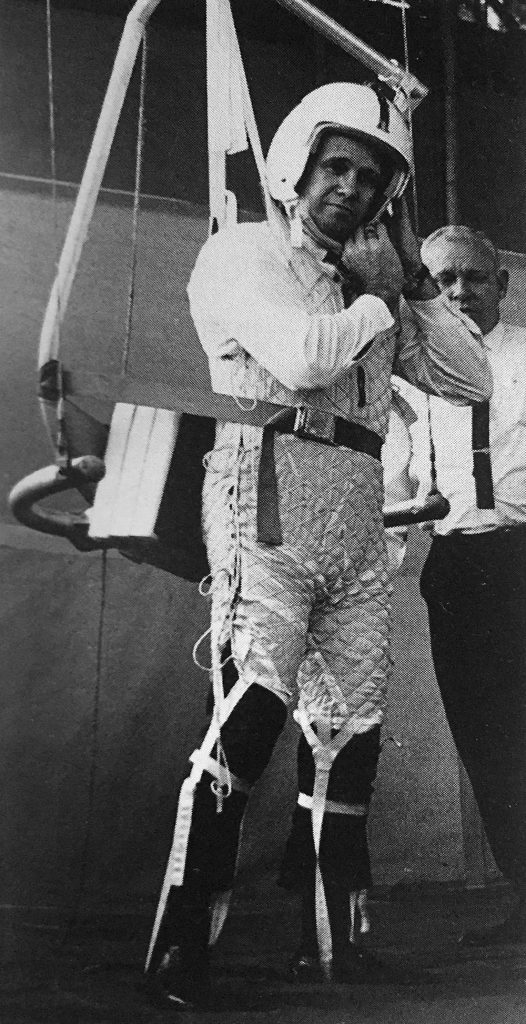 A person in a harness wearing a padded white outfit