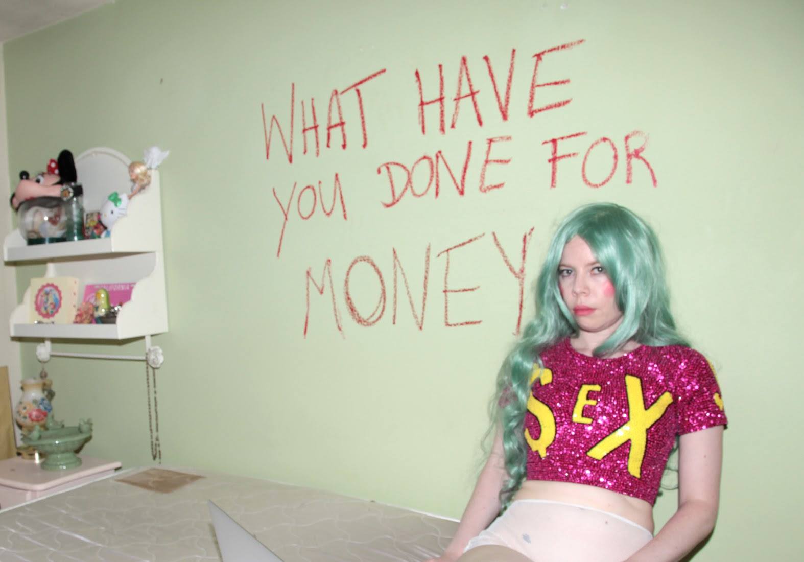 'What have you done for money' written in red on a wall