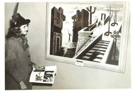 A person in a hat looking at a painting