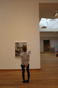 A person admiring artwork on a wall