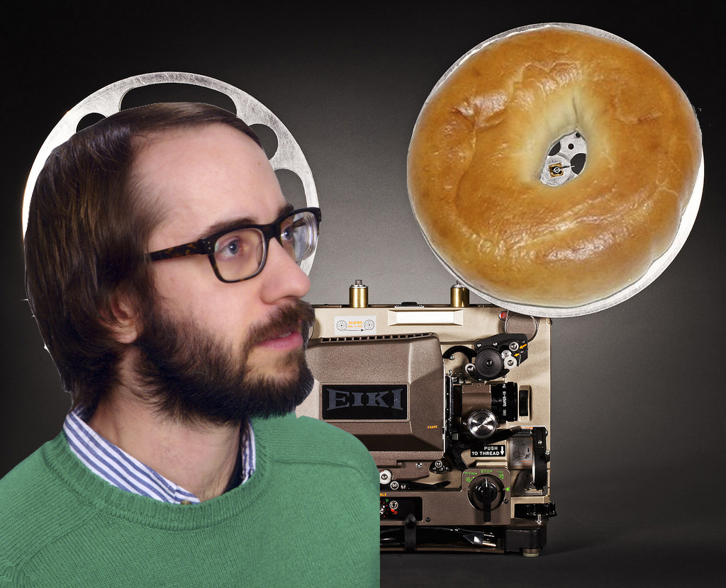 A person and a bagel in front of a movie projector