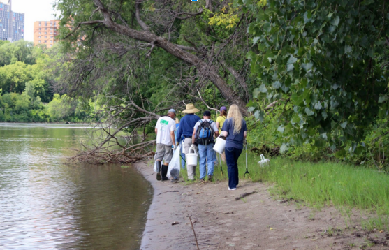 A group of people walking along a river bank