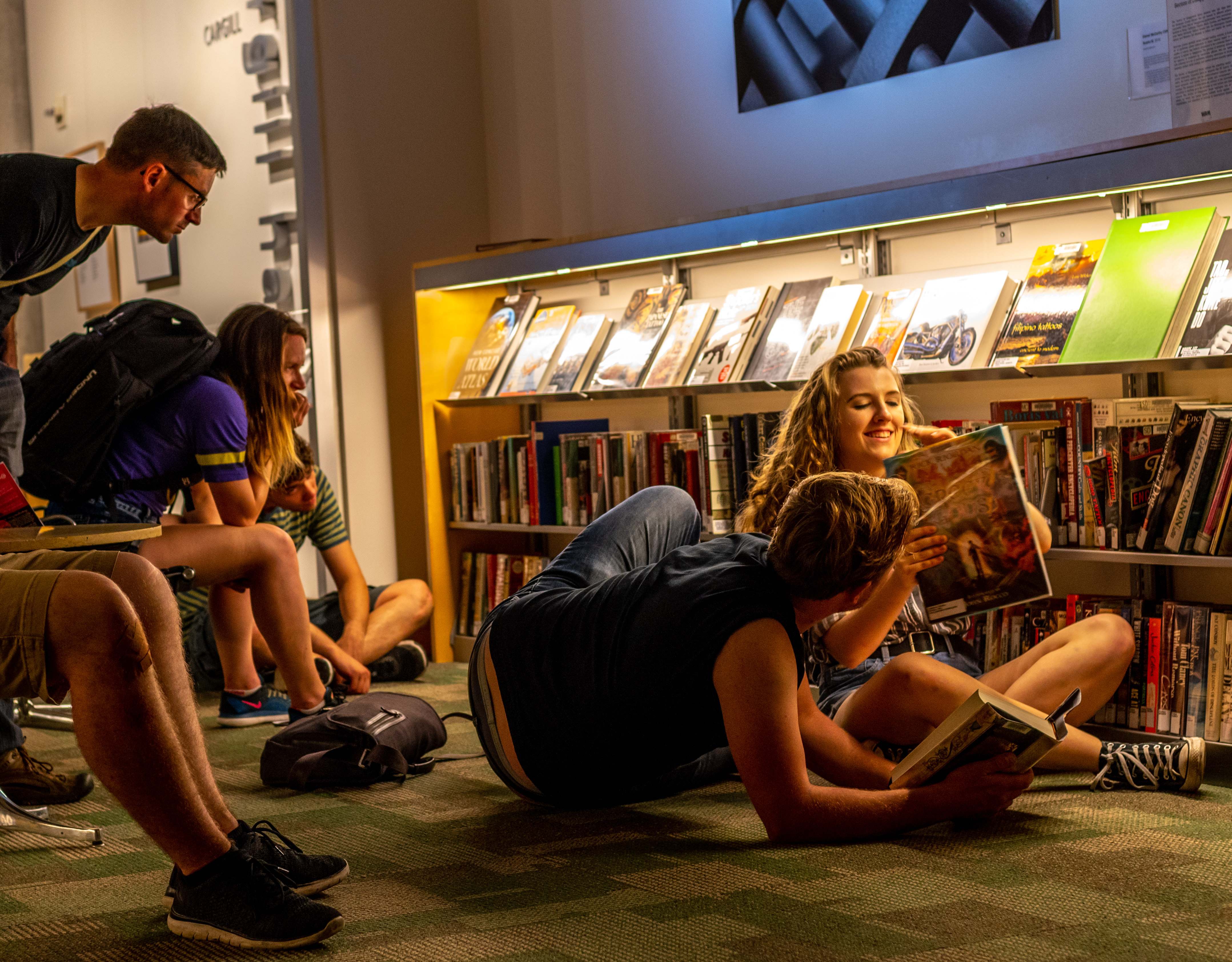 people sitting and reading surrounded by books