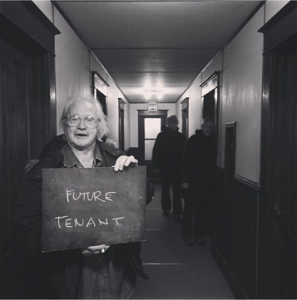 A person in a hall holding a sign