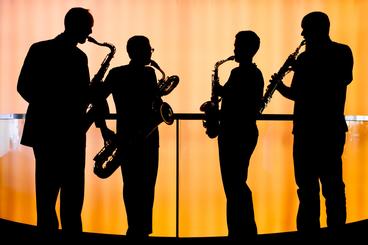4 silhouettes of people playing instruments