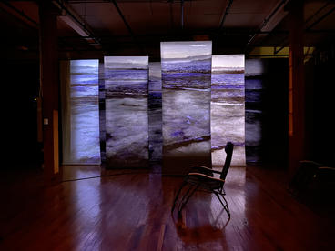 chair in front of screens depicting waves on water