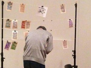 A person crouching in front of notes on string