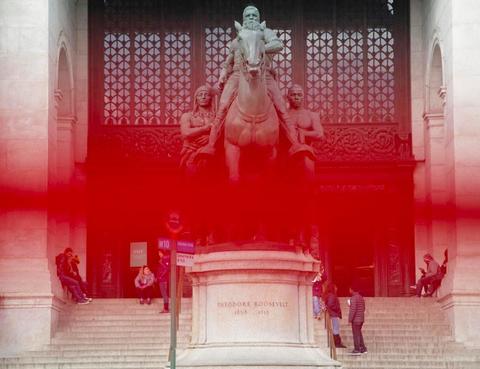 A statue of Theodore Roosevelt in front of an entrance to the American Museum of Natural History with a red line obscuring the middle third of the photograph
