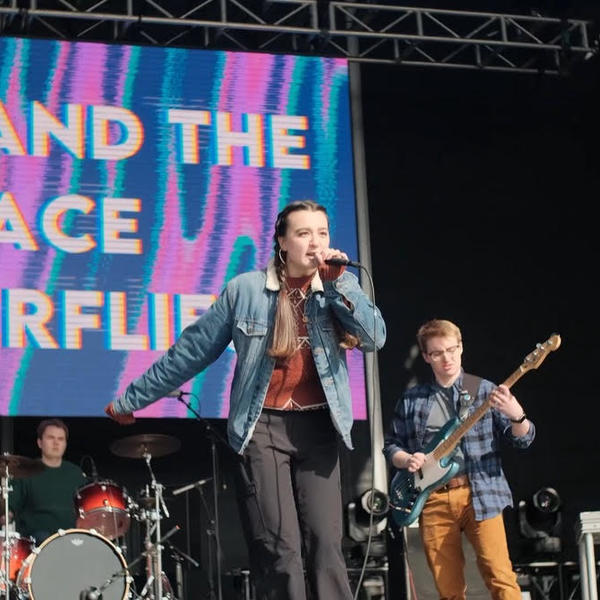 A female presenting vocalist performs with her band at a concert